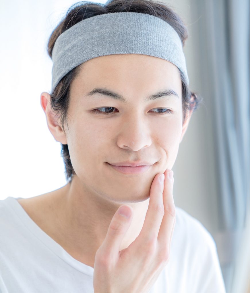 Man with good skin touching his face