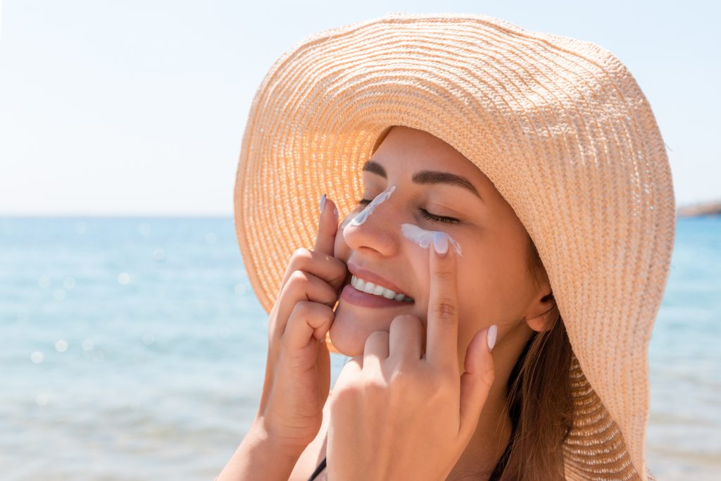 Woman applying sunscreen on her face